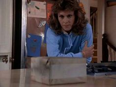 a woman sitting at a table with a box in front of her on the counter