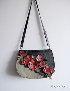 a handbag with flowers on it hanging from the wall next to a white wall