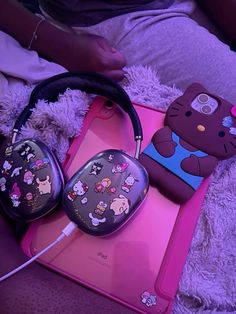 there is a hello kitty case and headphones on the bed