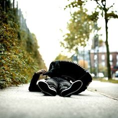 a person laying on the ground in front of some bushes