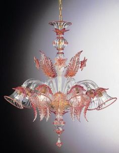 a glass chandelier hanging from a ceiling in the shape of flowers and leaves