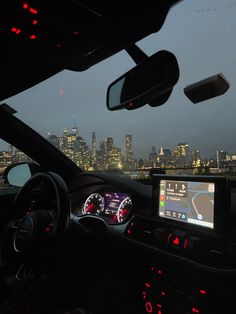 the dashboard of a car with city lights in the background