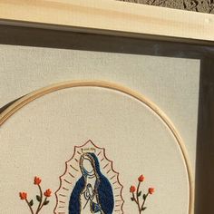 a cross stitch picture with an image of the virgin mary on it