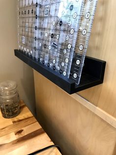 a wooden table topped with a cutting board next to a wall mounted shelf filled with bottles