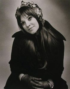 an old photo of a woman with long hair wearing gloves and a flower in her hair