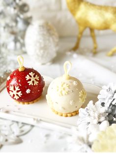 two desserts are sitting on a white plate with snowflakes around the edges