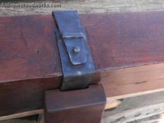 a close up of a wooden bench with a metal latch on it's side