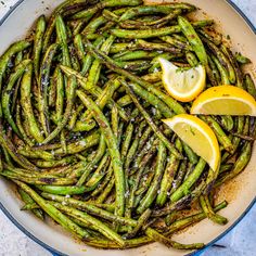 cooked asparagus with lemon slices in a pan