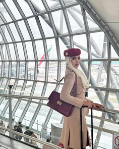 a woman is standing on the escalator at an airport with her handbag