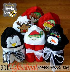 a group of stuffed animals sitting next to each other on a wooden floor in front of a christmas themed towel set