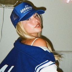 a woman wearing a baseball cap and blue shirt with the word's on it