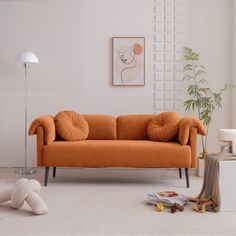 an orange couch sitting in a living room on top of a white carpeted floor