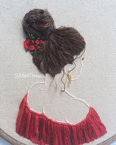 a woman's head is embroidered onto a white piece of fabric with red thread