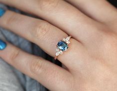 a woman's hand with a blue and white diamond ring