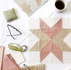 some crafting supplies are laid out on a table next to a cup of coffee