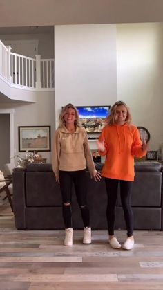 two women standing next to each other in a living room