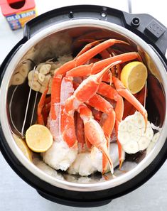 steamed crab legs in an instant pot with lemons and cashews on the side