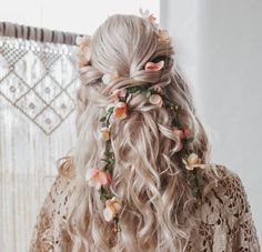 a woman with long blonde hair and flowers in her hair