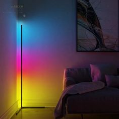 a living room with a couch and a colorful light on the wall next to it