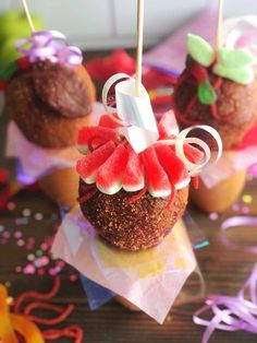 some cupcakes with watermelon and white frosting on them sitting on top of paper napkins