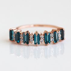 London Blue Topaz Wedding Band, Rose Gold Wedding Band, Topaz Stacking Band Topaz Half Eternity Band Gift Ring for Women Anniversary Ring Welcome to Rockstiffart Experience stunning jewelry which compliments your style everyday, All the items in my shop are hand made items and are crafted by our Master Goldsmith in our workshop, We pay a lot of emphasis on the making of the ring and we always assure you that we will provide best quality products every time toy you, Detailed description of the product *Main Stone: Topaz  *Main Stone Creations: Lab Created *Main Stone Size: 2x4mm *Main Stone Color: Blue *Main Stone Shape: Baguette *Birthstone Month: September *Secondary Stone : CZ Diamond  *Secondary Stone Shape: Round  *Secondary Stone Color: White  *Secondary Stone Size : 2mm  Jewelry Type Blue Topaz Wedding Band, Baguette Cut Ring, Rose Gold Wedding Band, London Blue Topaz Ring, Rose Gold Wedding Bands, Big Rings, Eternity Wedding Band, Rose Gold Wedding, Gift Ring