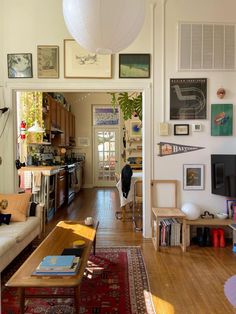 a living room filled with furniture and lots of pictures on the wall next to a doorway