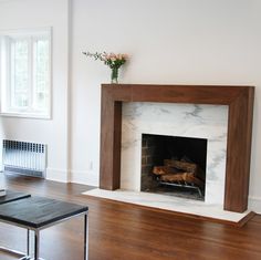 an empty living room with a fireplace in the center