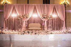 an elegant wedding setup with pink drapes and flowers