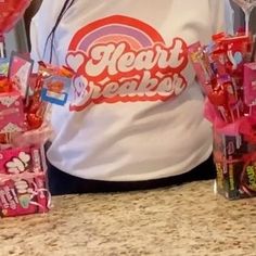 a person standing in front of some candy bags and lollipops on a counter