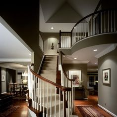 a staircase in a house with wood floors and white railings on the second floor