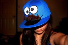 a girl wearing a blue hat with a mustache on it