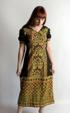 FREE DOMESTIC SHIPPING!  <3♥ Lovely vintage 1970s African print boho maxi dress!♥ Black with golden yellow, red and green ornate design!  Makes me have Egyptian vibes for some reason. ♥ Cute puff sleeves! Empire waist style.♥ Metal zip in the back. ♥ In great condition!  Cotton, cotton blend. * measurements when flat *Bust - 16" acrossShoulders - 14" acrossWaist - 13" acrossHips - 20" acrossBodice length - 12"Length - 49"Fits like a small,xs.No stretch.** I do ship worldwide!For more vintage cut Floral Floor, Ornate Design, Ethnic Dress, Mountain Man, Boho Maxi, African Attire, Boho Maxi Dress, Novelty Print, Printed Maxi Dress