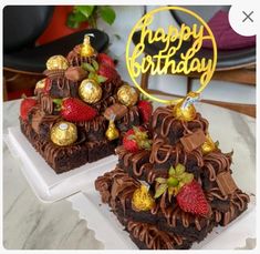 two cakes with strawberries and chocolate frosting are on a white plate that says happy birthday