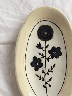 a white bowl with black flowers painted on it