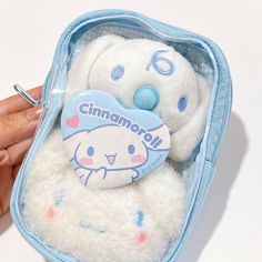 someone is holding a small stuffed animal in a blue case that says, cinnamon roll