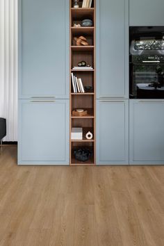 an empty room with wooden floors and blue cupboards on either side of the wall