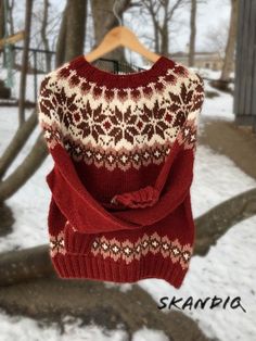 a sweater hanging on a clothes line in the snow