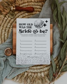 a wedding game is on top of a basket with greenery and a wooden ring