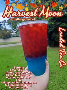 a hand holding up a cup with liquid in it and the words harvest moon above it