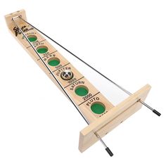 a wooden shuffle board with three green buttons and two black pins on each side, in front of a white background