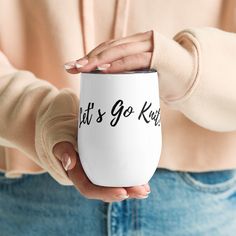 a woman holding a coffee mug that says it's go kart in black ink