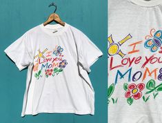 "Vintage I Love You Mom T Shirt  Loose fitting, all cotton, single stitch tee has a cute, bright 'I Love You Mom' graphic. Thin cotton. CONDITION:  Good condition, bright and clean. LABEL: Short Hills Tee, Made in Dominican Republic, 100% cotton SIZE: marked XL. ALWAYS check you measurements carefully and go by measurements, not by size! MEASUREMENTS: Underarm to Underarm: 25\" Bust/Chest: 48\" Waist: 48\" Length: 25\" Check measurements carefully! If it doesn't fit, I will accept returns of clo Flowers Mothers Day, Short Hills, Clean Label, I Love You Mom, Mothers Day Flowers, Love You Mom, Bright Flowers, Vintage Cotton, Dominican Republic