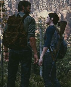 two people standing in the woods with backpacks