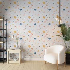 a living room with a chair, plant and wallpaper