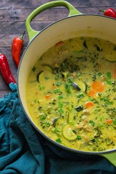 a green pot filled with soup and vegetables