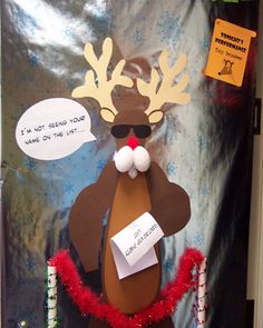 a door decorated to look like a reindeer with sunglasses and santa clause on his nose