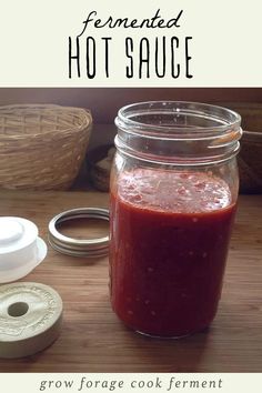 a jar filled with sauce sitting on top of a wooden table