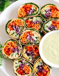 a white plate topped with lots of veggies next to a bowl of ranch dressing