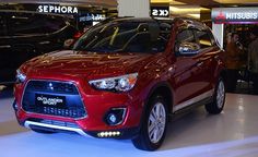 a red car is on display in a showroom