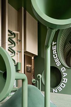 the inside of a building with green pipes and large letters on the wall behind it